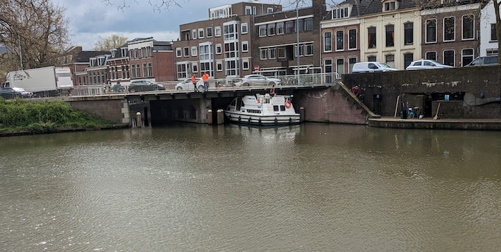 Plezierjacht komt klem te zitten onder brug bij Tolsteegsingel in Utrecht; brandweer helpt boot weer op weg