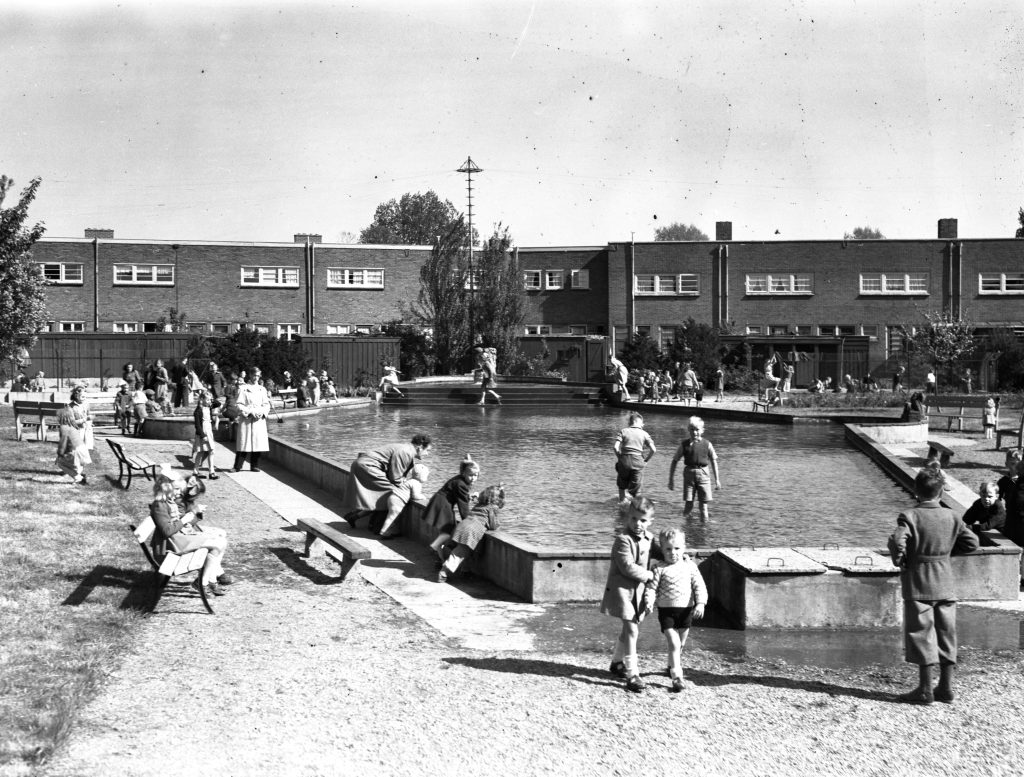 •Het zwembad achter de huizen aan de Jan van der Doesstraat in de Driehoek met het kinderbad met spelende kinderen, rond 1953 (foto Lauwers, G.J., HUA catalogusnr 55811)