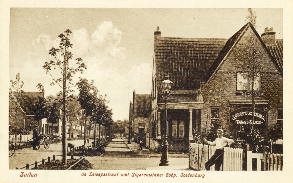 •Gezicht op de De Lessepsstraat te Zuilen uit het zuidwesten, met links de ingang van de Galvanistraat en de Tabaks- en Sigarenwinkel van Coöperatie Oostenburg, rond 1920 (foto HUA, Catalogusnummer 753).